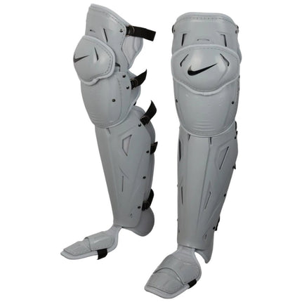 A pair of Nike shin guards in light gray with black accents, including the Nike swoosh logo on the front, shown against a plain white background.