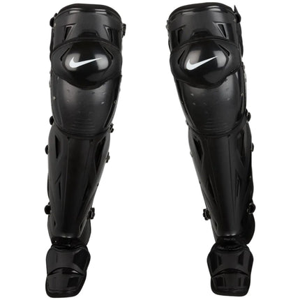A pair of black Nike shin guards for sports like soccer or martial arts, shown against a light gray gradient background.